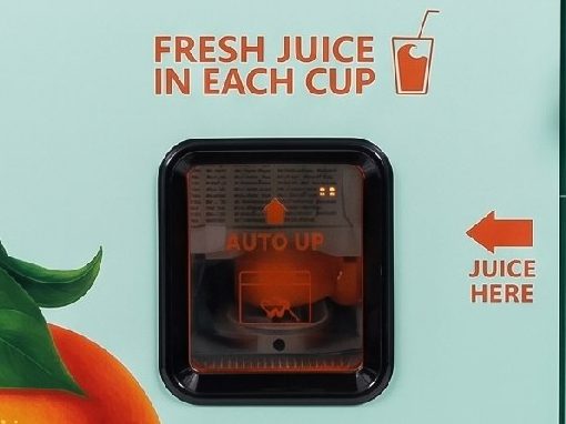 The cup dispensing window of a Squeeze Station machine, marked fresh juice in each cup