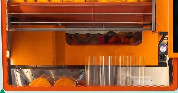 Inside the juicing window of a Squeeze Station machine, with the squeezer and the cups